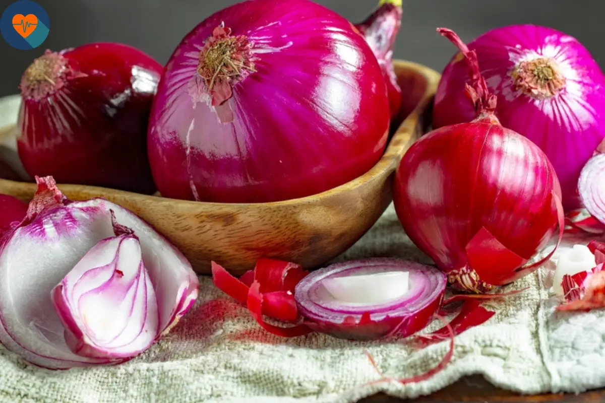 Red onion, whole and chopped, in a kitchen bowl on the table.